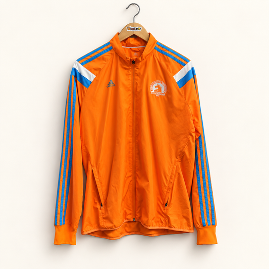 Adidas orange and blue striped sleeve jacket on warm off white editorial background