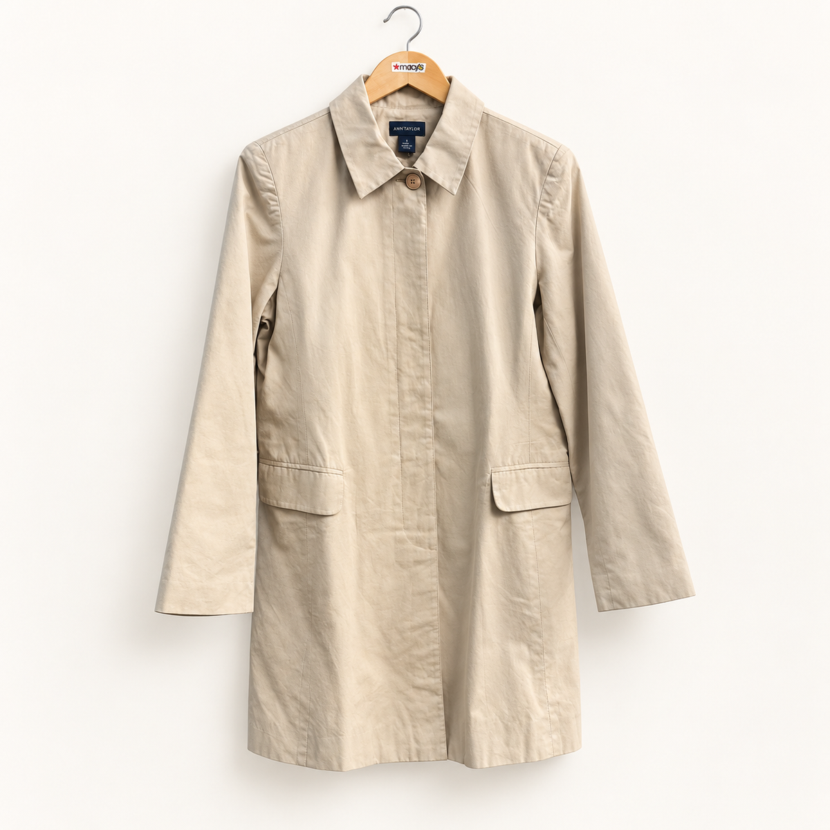 Ann Taylor beige trench coat on warm off white editorial background
