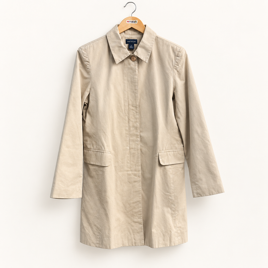 Ann Taylor beige trench coat on warm off white editorial background