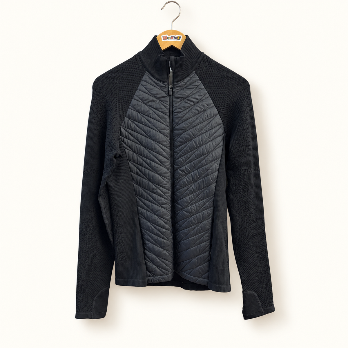 Athleta black quilted knit jacket on warm off white editorial background