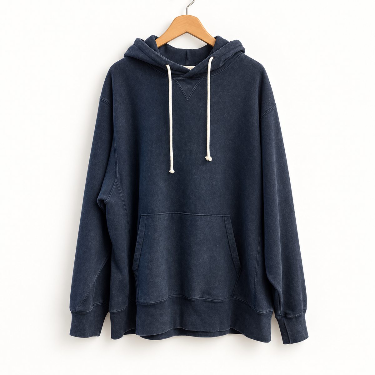 Champion navy hoodie on warm off white editorial background