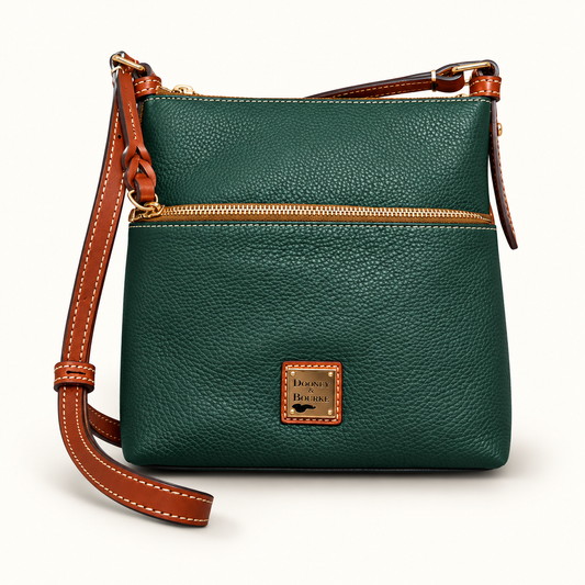 Dooney and Bourke green leather crossbody bag on off white editorial background