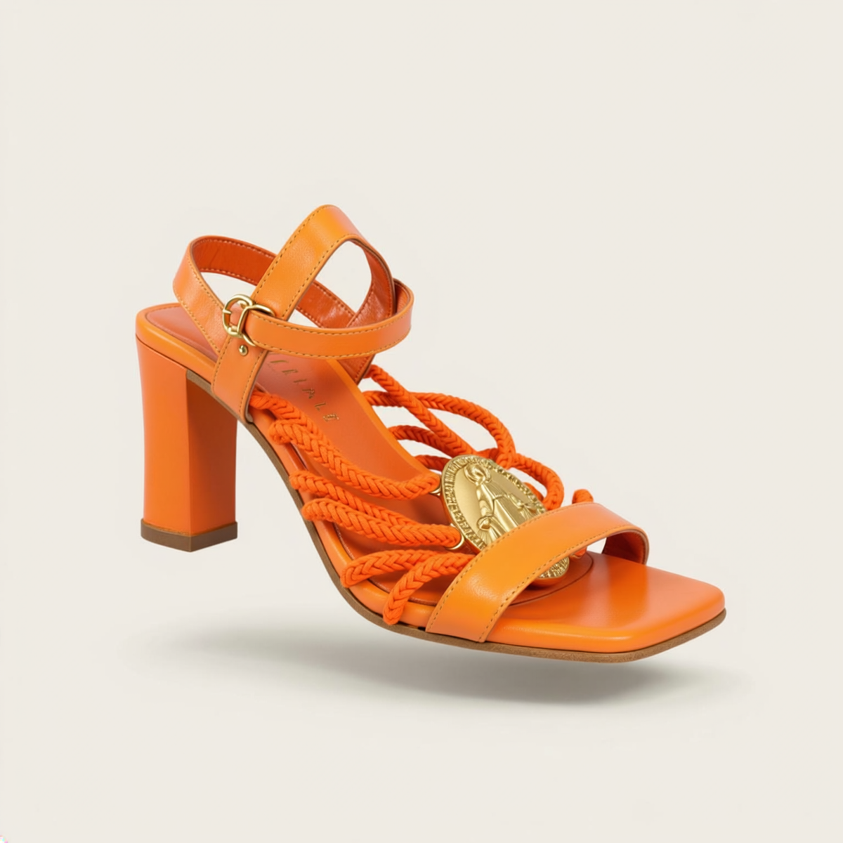 Fete Imperiale Orange Rope Medallion Clear Heels on off-white editorial background