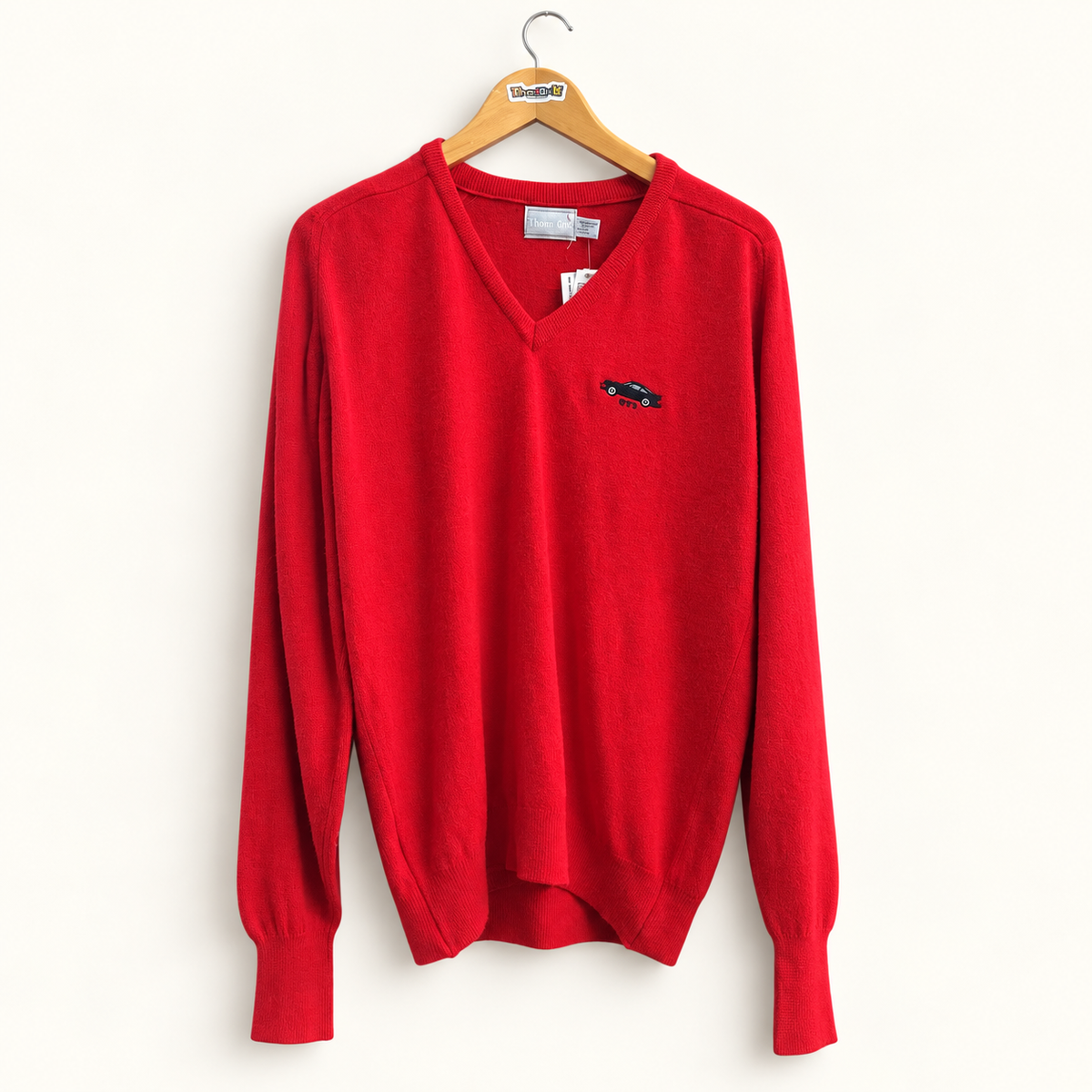 Highland Vintage red V neck sweater on warm off white editorial background