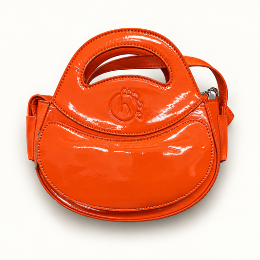 Homage Year orange Ovum bag on off white editorial background