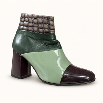 John Fluevog sage green and purple ankle boot on off white editorial background