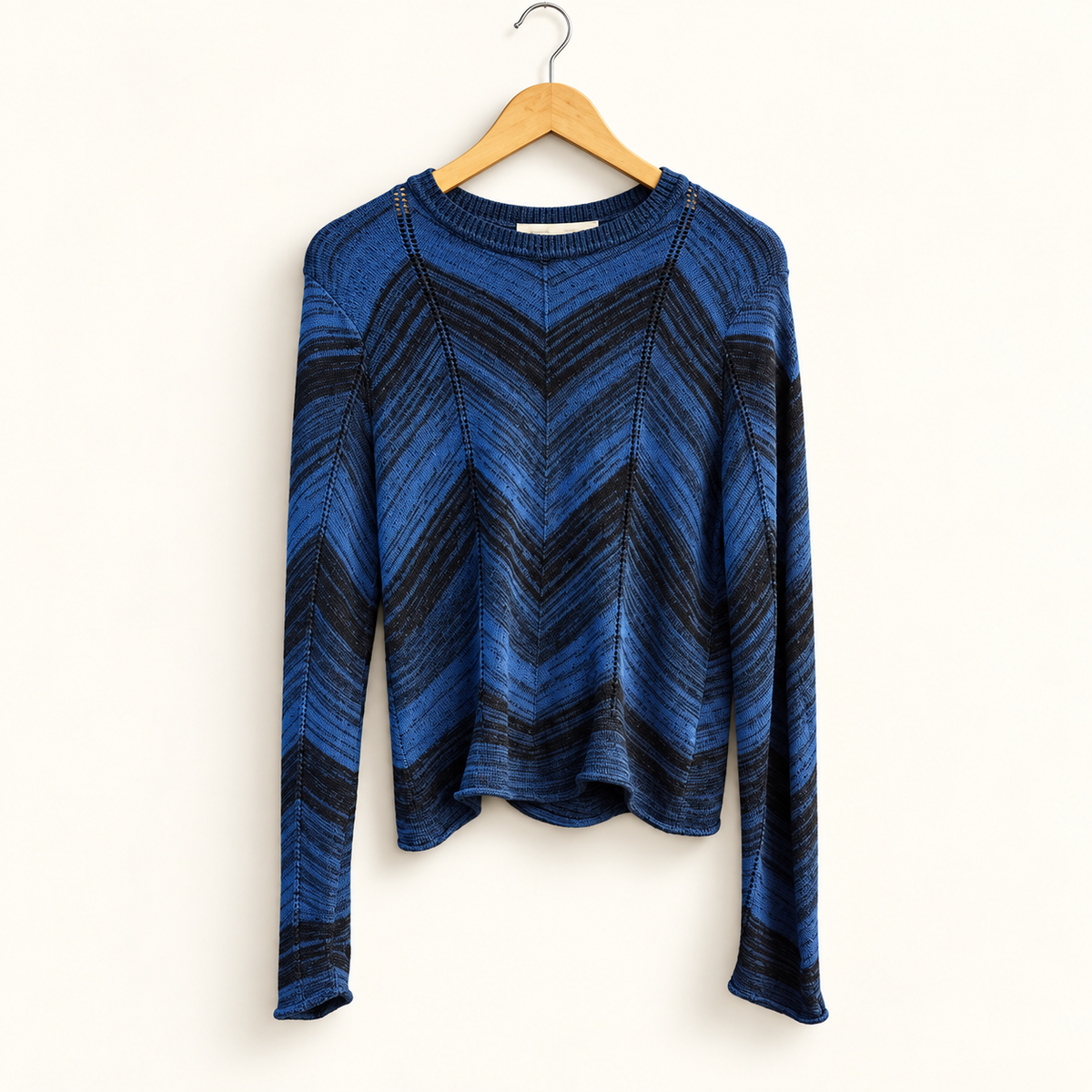 Proenza Schouler blue and black patterned sweater on warm off white editorial background