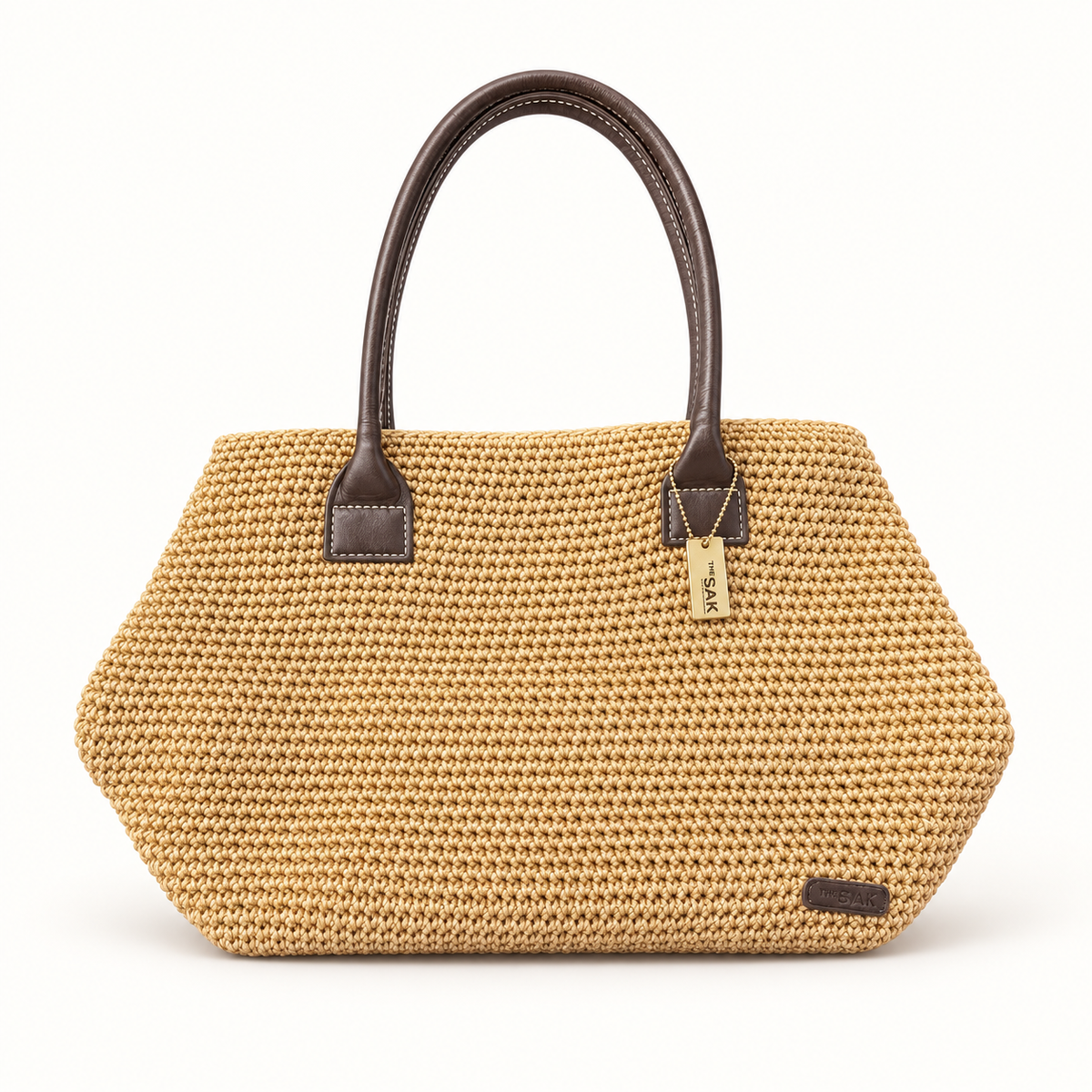 The Sak woven tan tote with brown handles on off white background