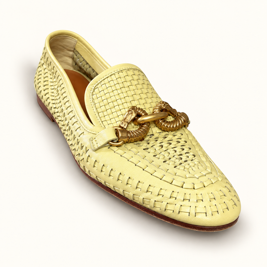 Tory Burch beige woven loafers on off white editorial background