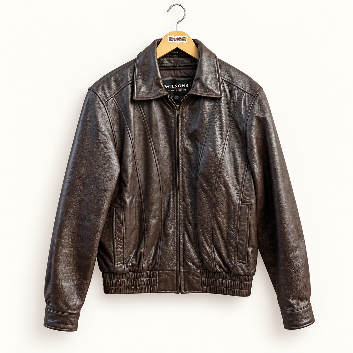 Wilsons chocolate brown leather bomber jacket on warm off white editorial background